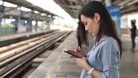 一名女性在地铁站使用智能手机