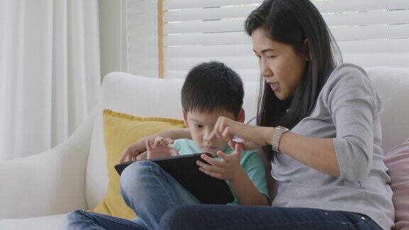 孩子和妈妈喜欢周末活动一起在家玩在线游戏