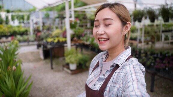 年轻的亚洲女商人作为农民使用数字平板电脑在她的有机农场温室开始小的和新的业务