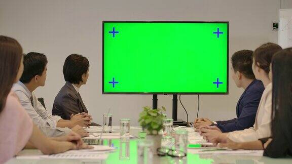 创意业务团队看着会议室的绿色屏幕为发言人鼓掌