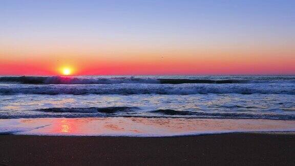 美丽的日出在海浪和海滩上海洋日落