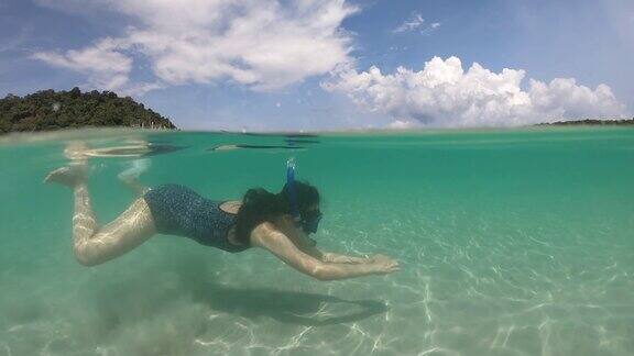 女人在比基尼浮潜异国情调的礁在岛上