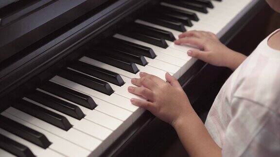 亚洲小女孩在家里练习弹钢琴