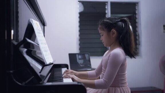 一个亚洲小女孩在线学习弹钢琴