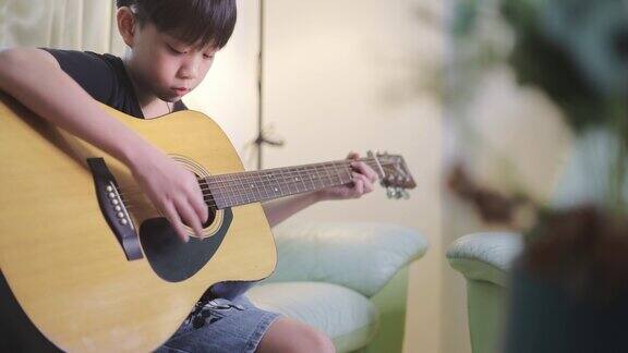 亚洲男孩弹奏原声吉他