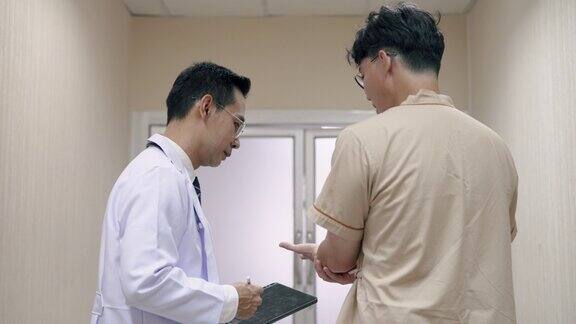 亚洲男性医生与男性病人谈论他的身体状况