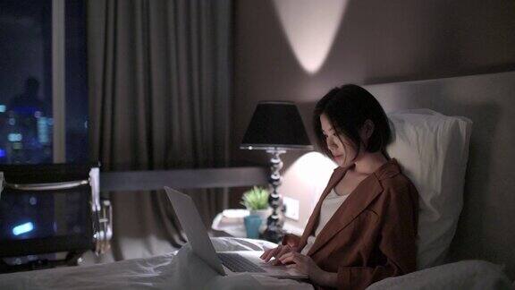 晚上在卧室里用笔记本电脑工作的亚洲中国美女
