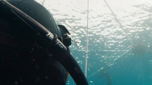 在公海自由潜水训练期间男性自由潜水员沿着绳索上升的特写肖像