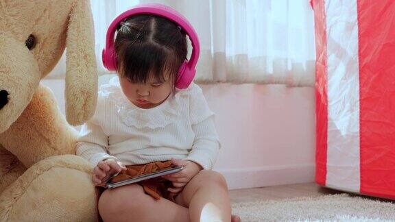 可爱的亚洲小女孩拿着智能手机玩手机
