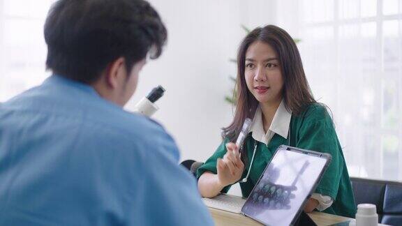 亚洲医生拿着x光片给病人看脑部x光片