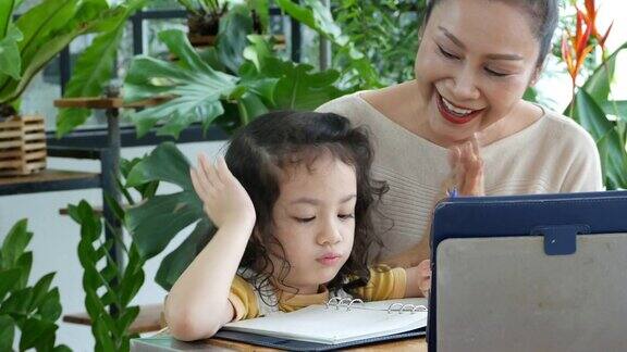奶奶教小女孩在温室里用数字平板电脑写字和学习家庭教育