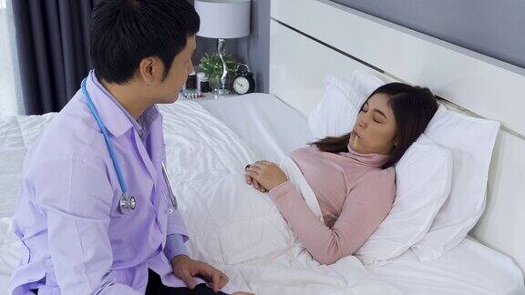 病人躺在床上医生用体温计检查她的体温