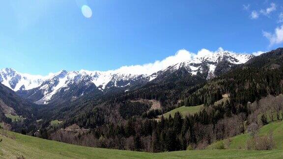 奥地利卡琳蒂亚卡拉万克地区春天高山和充满活力的绿色草地上的全景高山山脉被雪覆盖着Hochstuhl(Stol)和Kosiak的观点阿尔卑斯山脉