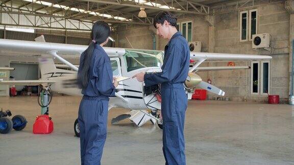下面是两名亚洲工程师在飞机机库边走边谈寻找维修方案的后景STEM概念中的女性