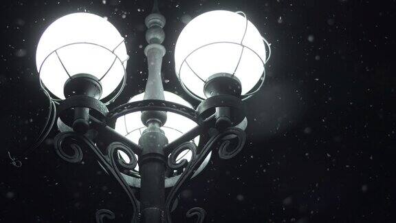 雪夜灯火通明近街灯在夜晚的雪花