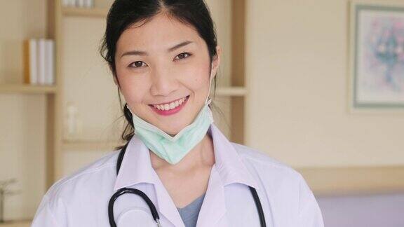 亚洲女医生完成检查工作后摘下保护性外科口罩肖像的护理妇女在医生袍脱下面具在医院健康职业新常态生活方式