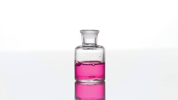 玫瑰精油滴入装有粉红色液体的透明瓶中