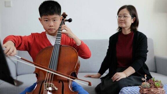 小男孩在家与老师练习大提琴