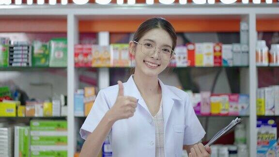 照片中一位美丽的亚洲药剂师站在药房服务台上自信地微笑着