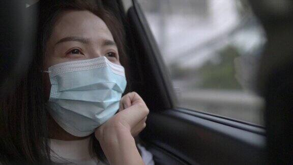 年轻女子戴着防护口罩坐在车里用消毒湿巾洗手