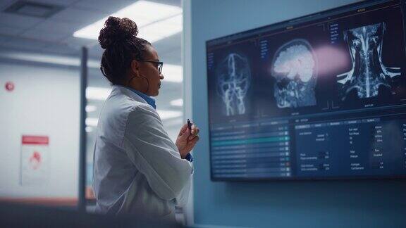 医学科学医院:自信的黑人女性神经学家神经学家神经外科医生用MRI扫描看电视屏幕思考病人的治疗方法拯救生命