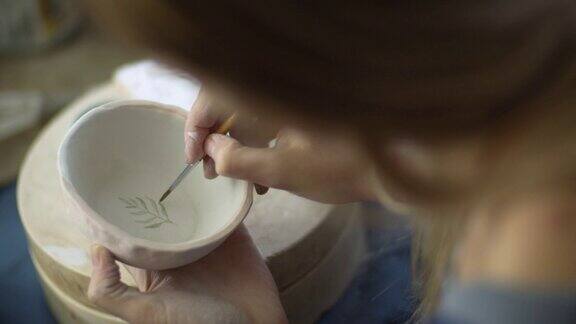 年轻女子在她的陶器作坊里手工制作陶器这是一种小型的商业理念