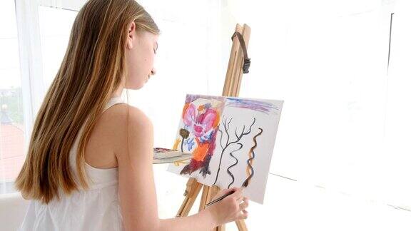 小女孩在艺术工作室的画架上画画