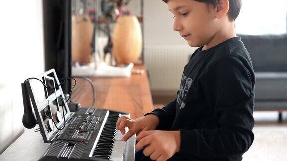 小可爱的男孩玩电子键盘钢琴乐器-音频可用