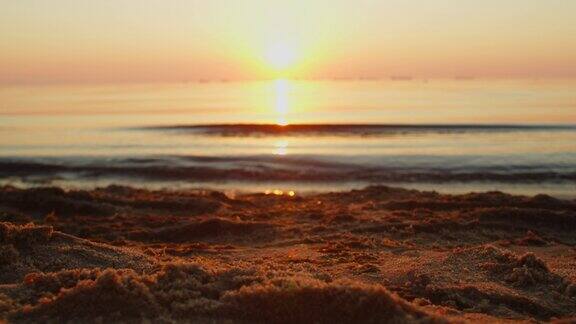 美丽的日出在沙滩上俯瞰平静的海浪