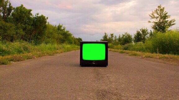 复古电视与色度键屏幕遗弃在乡村道路