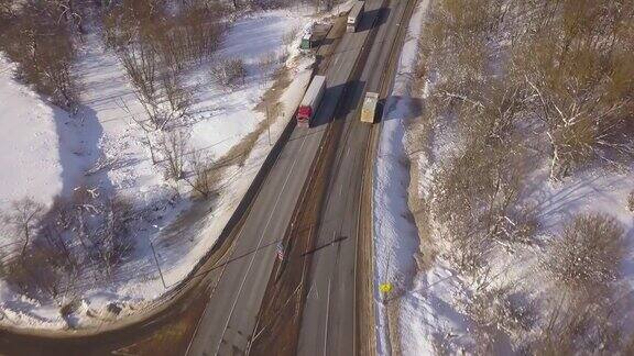 汽车和货车在冬季高速公路上行驶无人机在上面飞行鸟瞰图车辆在雪道上的冬季景观
