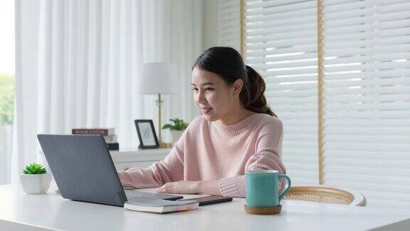 坦率的年轻迷人美丽的亚洲女商人在家远程工作或学习在线坐在舒适的工作空间在家里感觉快乐的隔离社会距离概念