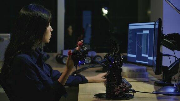 年轻的电子开发工程师在实验室测试创新机器人技术年轻的亚洲女性为机械机械手创造运动有技术或创新观念的人