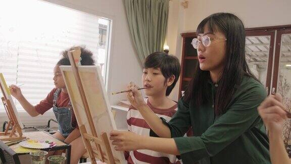 一位亚裔女老师在美术教室里教孩子们关于亚克力画的知识