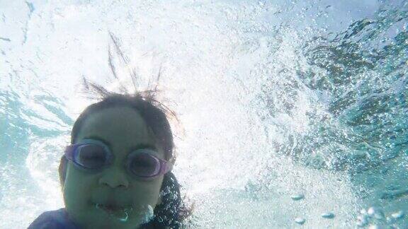 镜头:快乐的小女孩在水上乐园的滑梯上玩得很开心