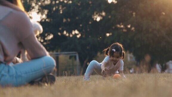 妈妈和女儿和小狗在公园里玩