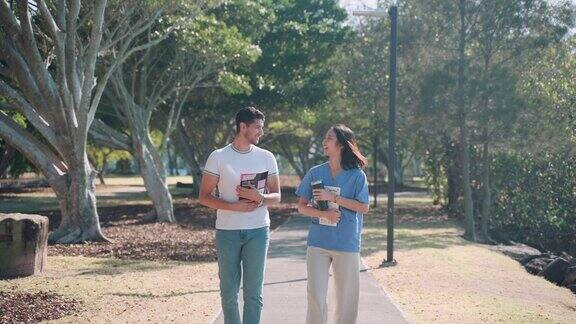 一对朋友的多样性亚洲和拉丁大学生拿着一本书在公园散步和聊天