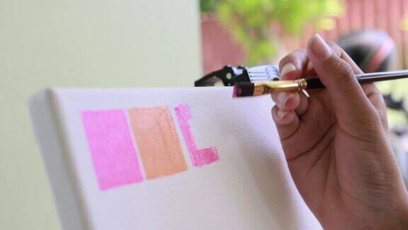 特写艺术家的手使用画笔在画布上创作练习丙烯绘画