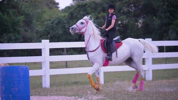 年轻的亚洲女孩喜欢在农场骑马女孩在牧场骑马训练