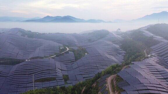 在晨雾中山顶太阳能发电厂的高角度视图