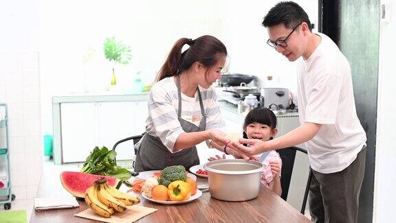 快乐的亚洲家庭在餐桌上一起准备食物的肖像