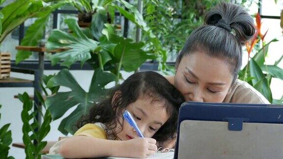 奶奶教小女孩在温室里用数字平板电脑写字和学习家庭教育