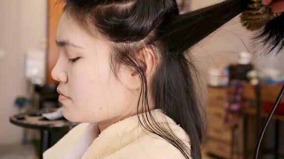 亚洲美女她使用美发沙龙的洗头和吹头发服务