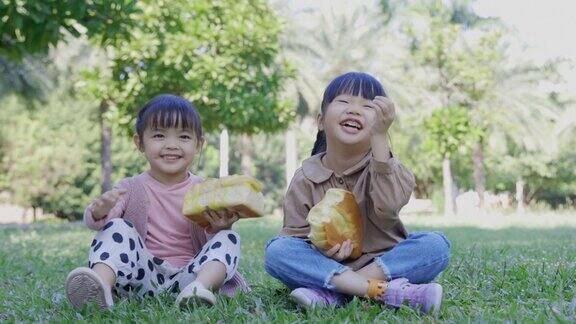 在公园野餐时孩子们吃面包