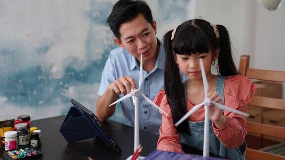 在家上学的女孩与她的父亲在家里学习清洁能源和可持续性