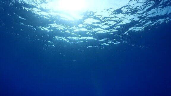 阳光和阳光光束的风景水面上的水下波浪缓慢的海洋风景为背景