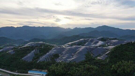 黄昏时分山峦起伏的太阳能发电厂鸟瞰图