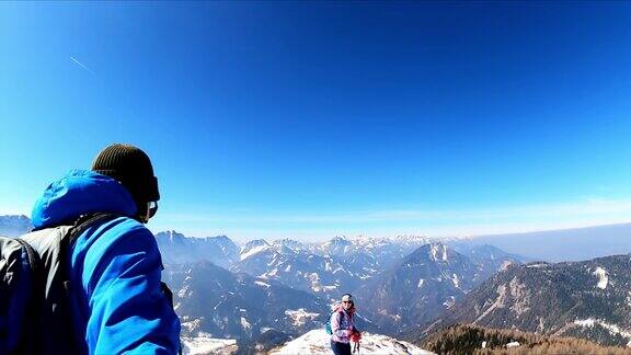 一对徒步旅行的夫妇在弗莱堡山的顶峰在冬季欣赏卡拉万克斯山脉的风景朱利安阿尔卑斯山位于卡林西亚与奥地利斯洛文尼亚接壤泽尔Pfarre朱利安阿尔卑斯山阳光明媚的一天自由