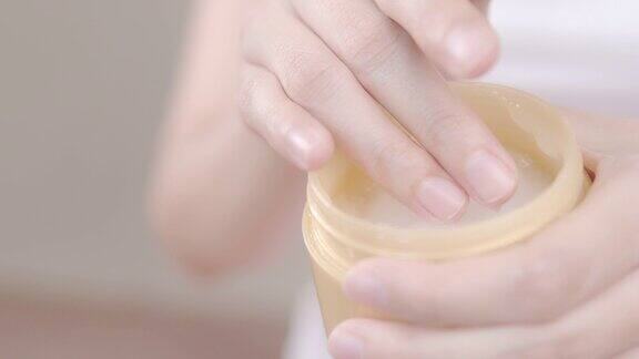 4k分辨率亚洲成年妇女使用手涂抹保湿化妆品霜在她的手身体保健