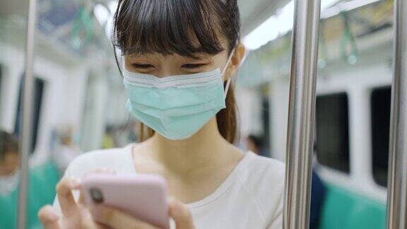 年轻女子在乘坐地铁时使用智能手机